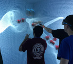 students standing in front of white grid, with red spheres
